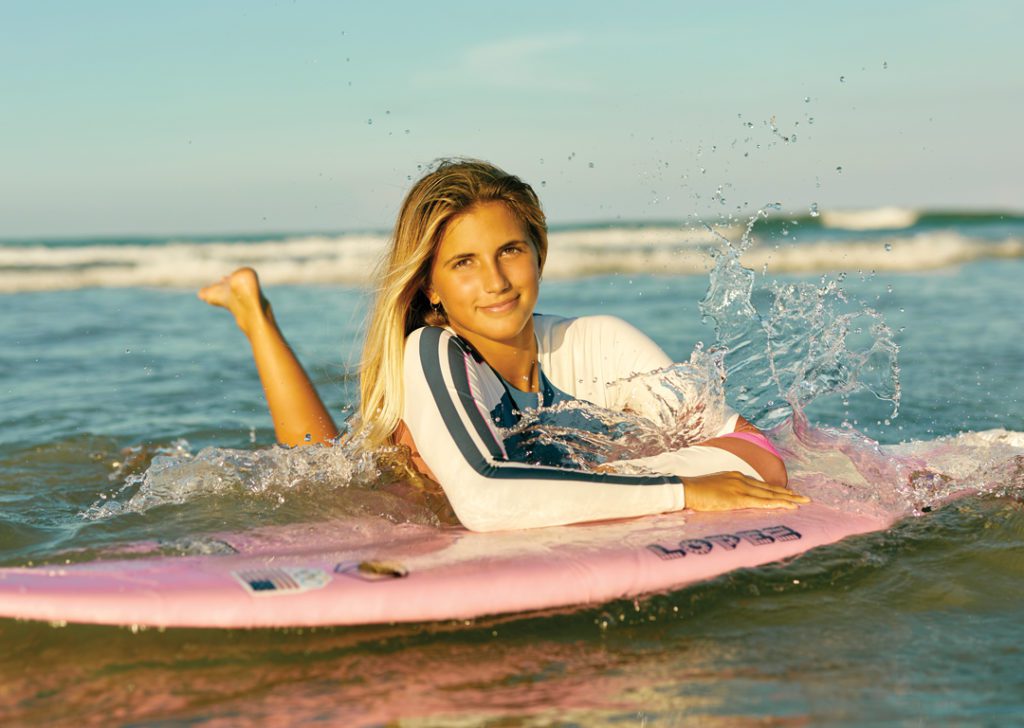 Zoe Benedetto relaxing on her pink surfboard