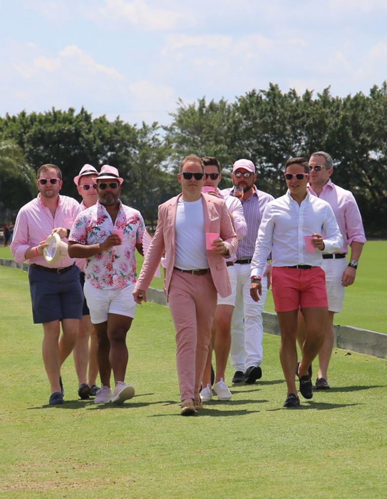 A crowd of people walking around the field at the Gay Polo Tournament