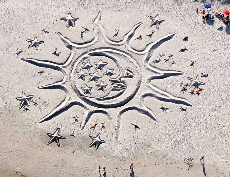 Craig Rubadoux ,,4-17 -11,,,Artist,Todd Brittingham of Fort Lauderdale FL, who has been doing Earthworks for the last 23 years, created a sand sculpture titled "Sun and the Moon" which is dedicated to the ending of the space shuttle program with stars dedicated to the lost space shuttle astronauts. Lying in the sculpture are volunteers that helped Todd construct the work of art at Jetty Park Sunday afternoon during a Earth Day celebration.