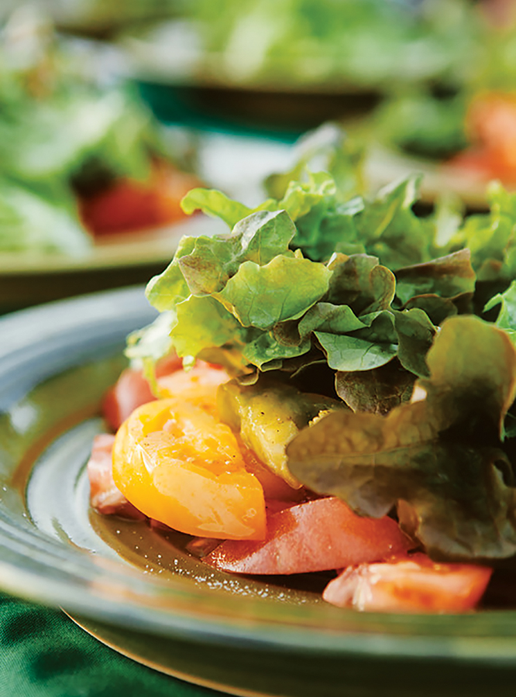 Red and yellow tomatoes, covered with leafy lettuce; Photography by Hannah Glogower