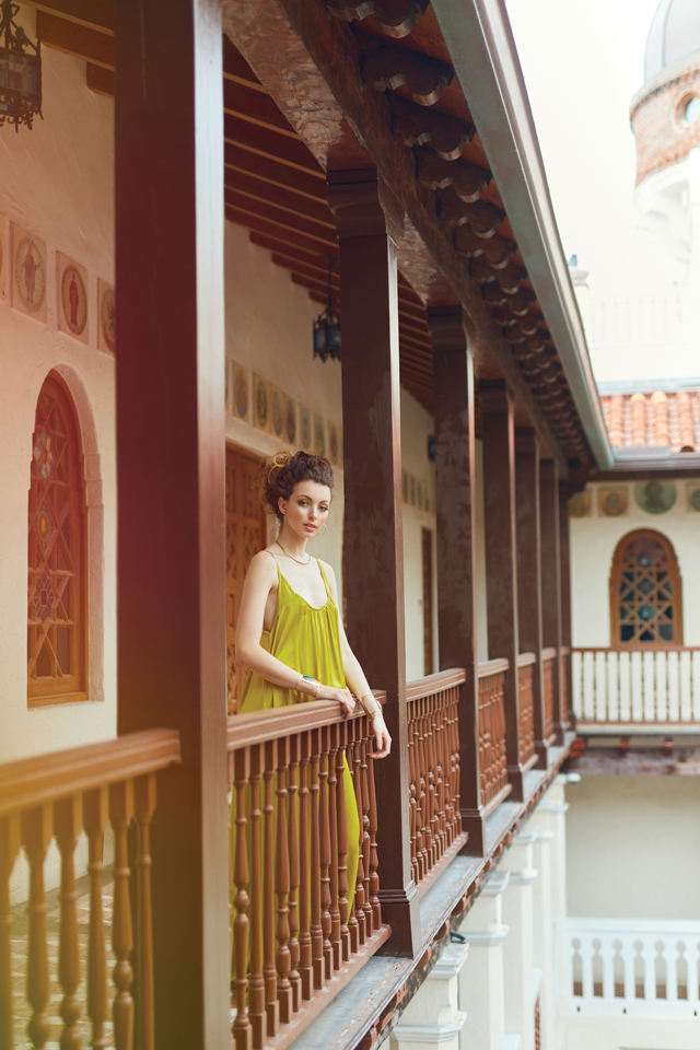 Krystoff in the chartreuse dress is on a balcony overlooking the courtyard. 