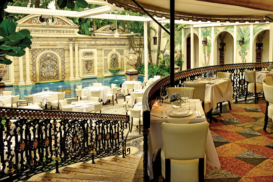 The Versace dining room overlooks the pool. Tables are set up ready for guests.