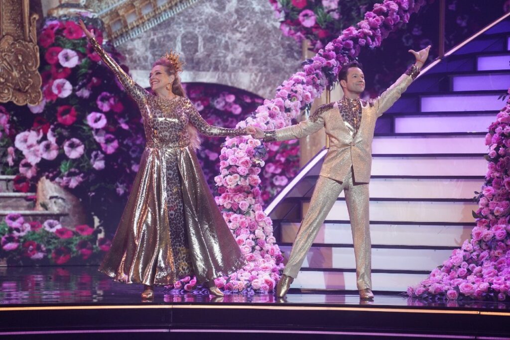 Carole Baskin and partner, dancing pro Pasha Pashkov, wear shiny animal print designs as they dance on the stage.